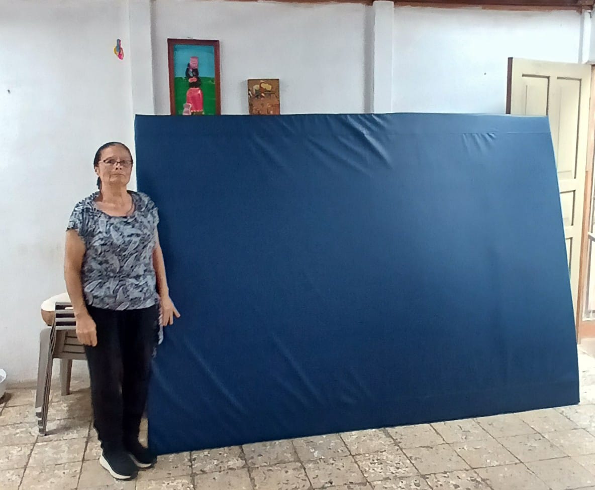 Vilma Villalta Suazo junto a un colchón fabricado en el taller